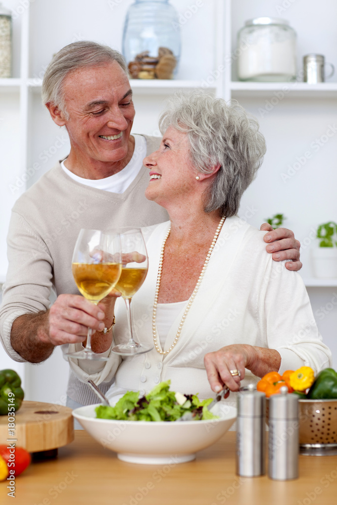 Senior couple in love eating a salad in the kitchen Senior couple in love eating a salad in the kitchen