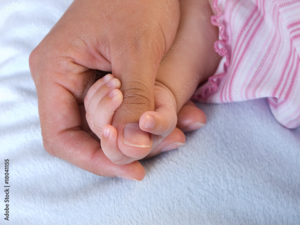 Babyhand umfasst den Daumen von Mutters Hand Babyhand umfasst den Daumen von Mutters Hand