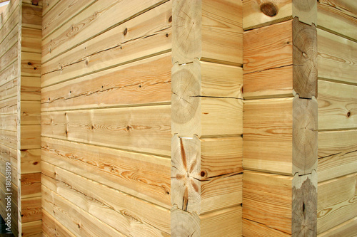 Wall and corner of planed pine log cabin