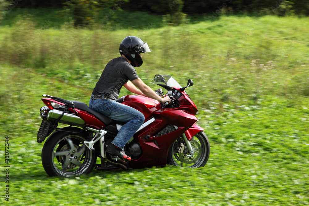 motorcyclist riding on meadow motorcyclist riding on meadow
