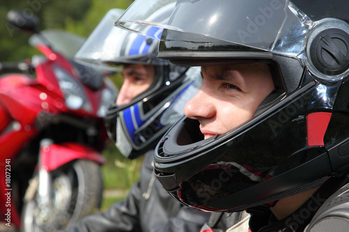 portrait of two motorcyclists sitting on country road near bike © Pavel Losevsky