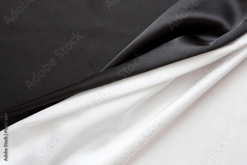 Fototapeta Naklejka Na Ścianę i Meble -  The beautiful silky brilliant black and white wavy fabric halved