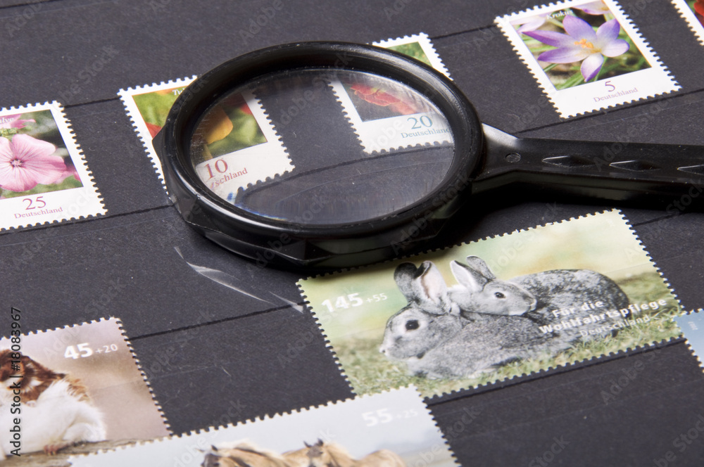 stamps and magnifying glass on white background
