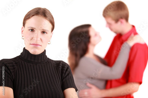 Portrait of jealousy girl with lovers in background, studio shot
