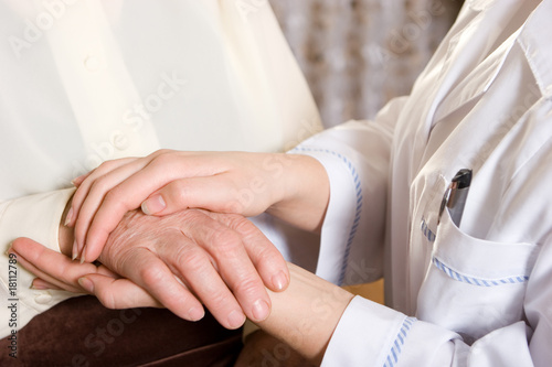 Caring hands of a nurse and elderly woman