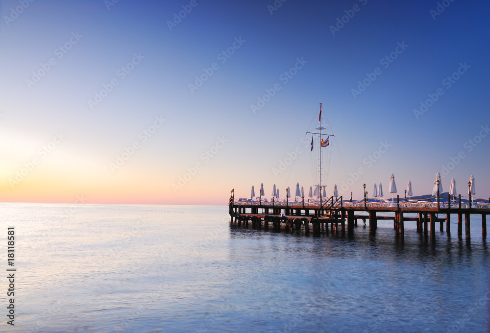 Pier lighted by sunrise glowing