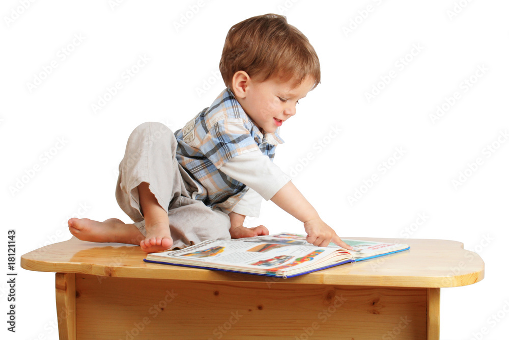 One smiling playing children reading the book on the desk One smiling playing children reading the book on the desk