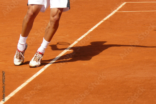 Athletic pose of a tennis player serving showing only feet