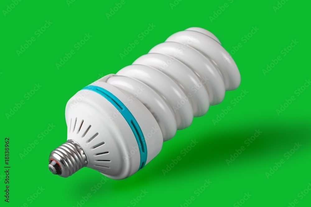 Economic light bulb standing on green background Economic light bulb standing on green background