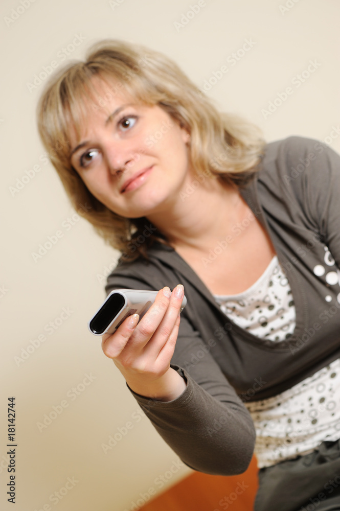 The woman with a television control panel. Selective focus The woman with a television control panel. Selective focus