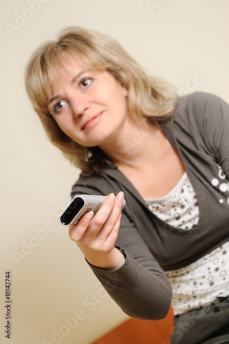 The woman with a television control panel. Selective focus