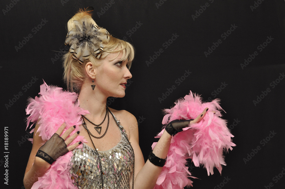 Young pretty lady  with pink feather boa on black background