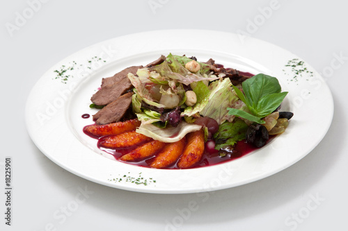 Salad from duck meat, oranges, leaves of salad and nuts and sauc