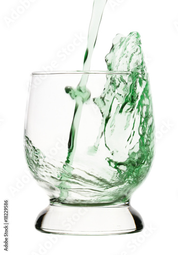 Splash, green drink is being poured into glass
