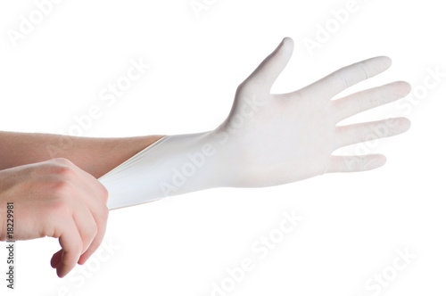 Hands of person putting on a medical glove isolated on white © Vladyslav Bashutskyy