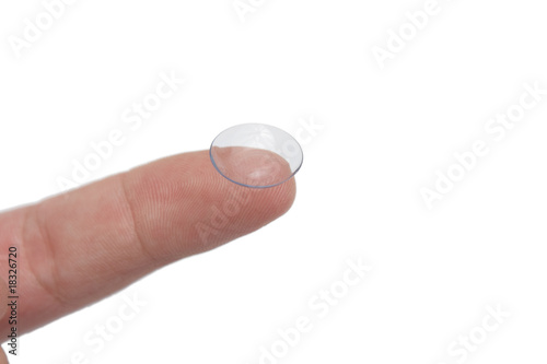 one finger holding one contact lens, closeup photo