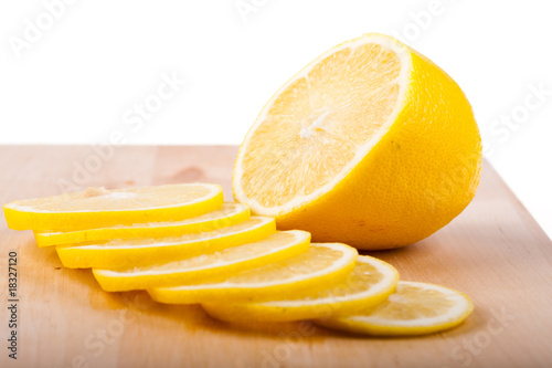 The lemon cut by segments lies on chopping board.
