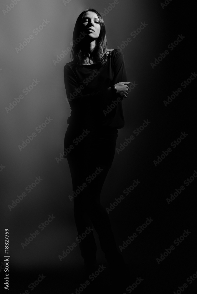 Dark contrast shot of beautiful fashion model on dark Dark contrast shot of beautiful fashion model on dark
