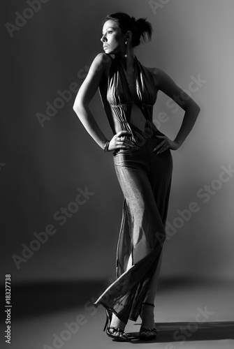 Fashion model in long clothes on dark background