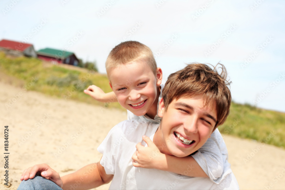happy teenager and kid on the beach happy teenager and kid on the beach