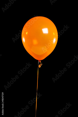 Orange party balloon on black