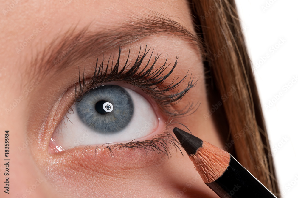 Fototapeta premium Blue eye, woman applying black make-up pencil