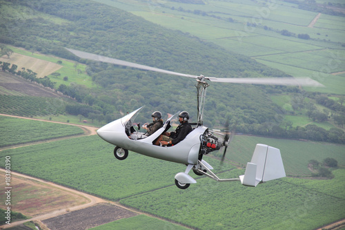Fotografie, Tablou Autogyro flying over the tropical landscape