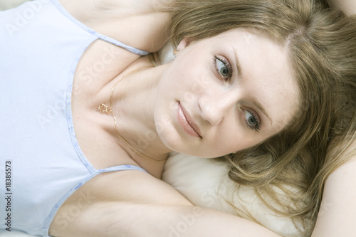 bored woman lying down ot he bed over white background