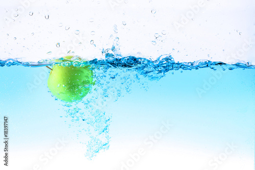 Green apple under water splashing
