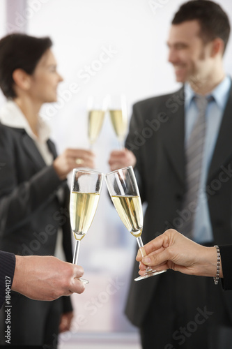 Business people raising toast with champagne