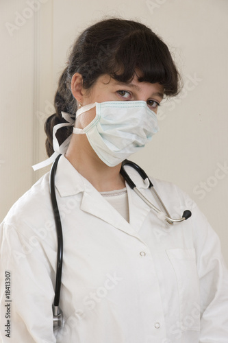 Femme médecin en blouse blanche avec masque anti-grippe