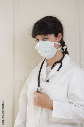 Femme médecin en blouse blanche avec masque anti-grippe