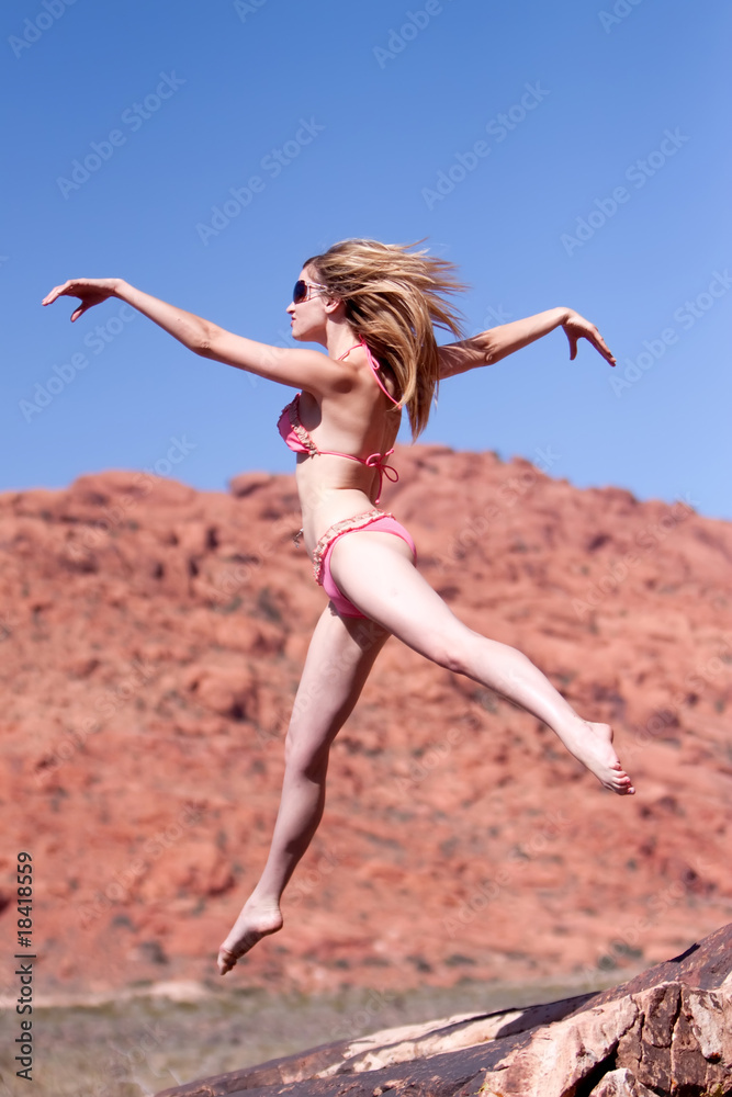 Woman in bikini jumping outdoors Woman in bikini jumping outdoors