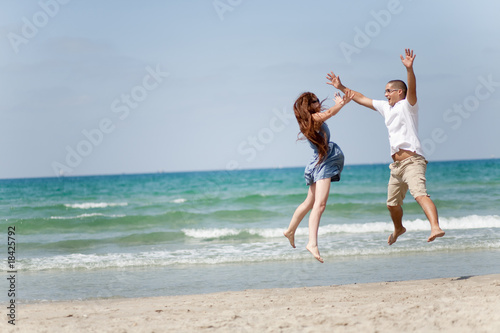 Happy young couple having fun on the beach