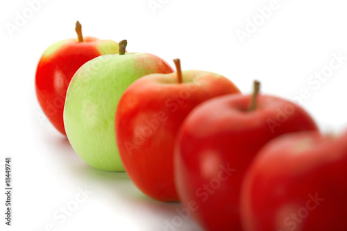 Group of red apples with one green one