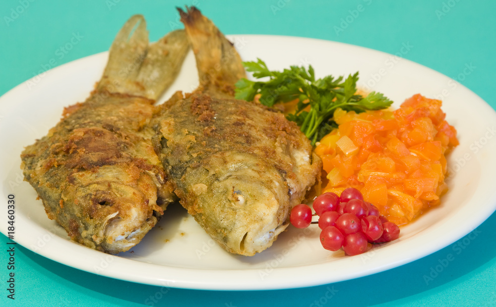 Fried fish in plate on a green background