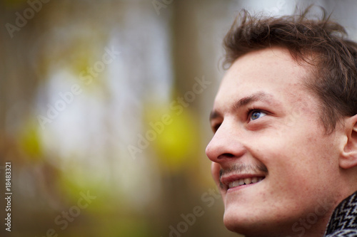 Happy young man looking up at copyspace