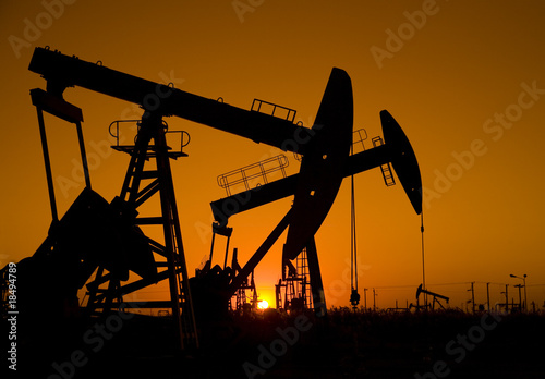 Silhouette of oil well with sunset