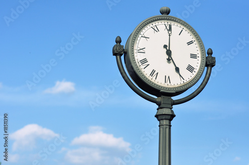 The big figured street clock against the blue sky photo