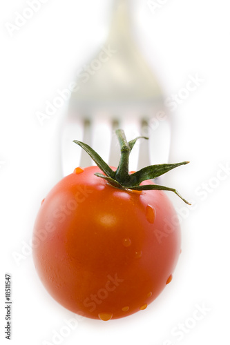 tenedor o cubierto pinchando el tomate