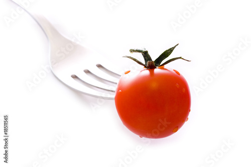 tenedor o cubierto pinchando el tomate