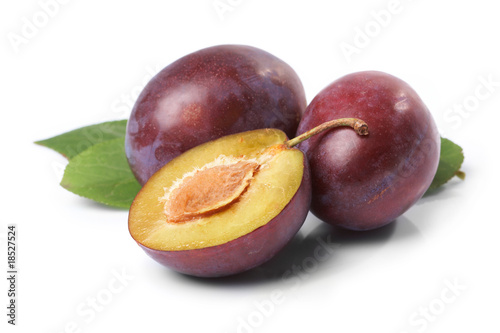 Plums and leaves on a white background.