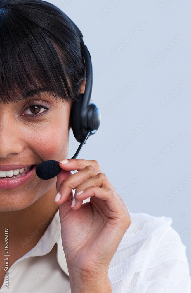 Close-up of smiling ethnic businesswoman working in a call cente Close-up of smiling ethnic businesswoman working in a call cente
