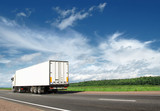 white truck speeding away on country highway under blue sky