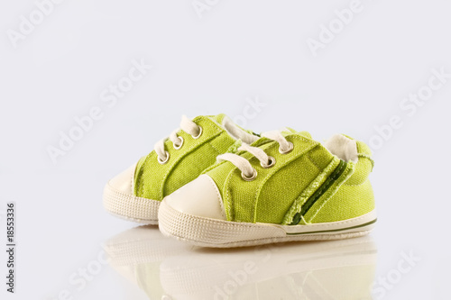 Green baby shoes on a white background