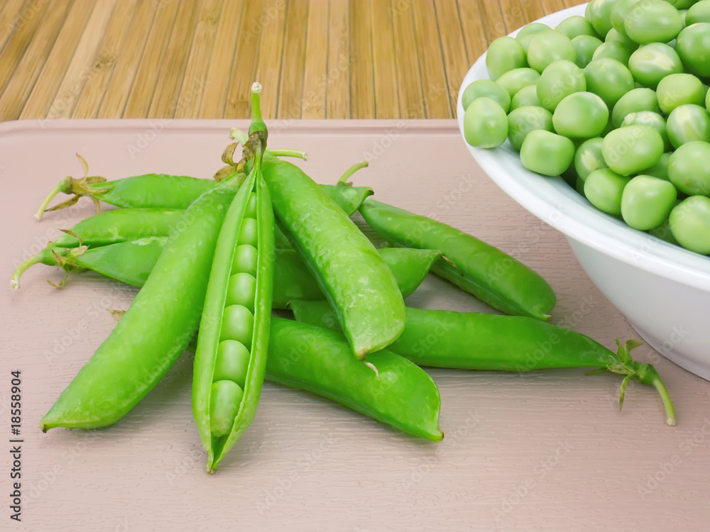 Pods sweet green peas and beans on a plate close-up Pods sweet green peas and beans on a plate close-up