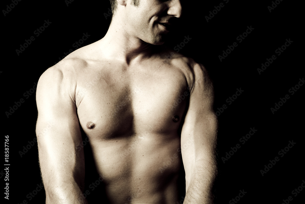 Fototapeta premium Muscular male torso on black background