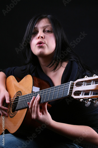 the woman plays on the acoustic guitar
