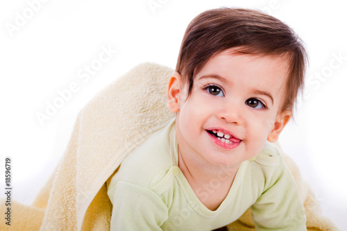 Infant crawling with towel and smiling