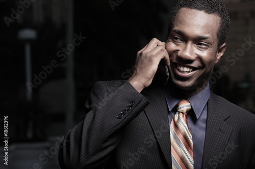 Handsome businessman smiling and talking on a cell phone